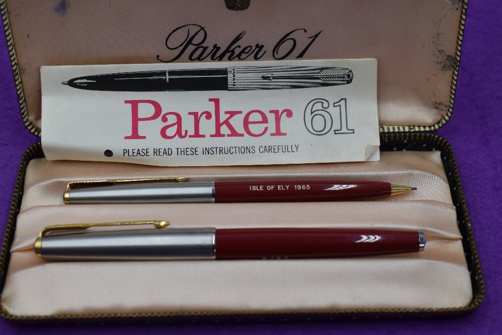 A boxed Parker 61 fountain pen and propelling pencil set, in red with brushed steel cap with gold