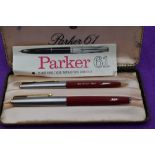 A boxed Parker 61 fountain pen and propelling pencil set, in red with brushed steel cap with gold