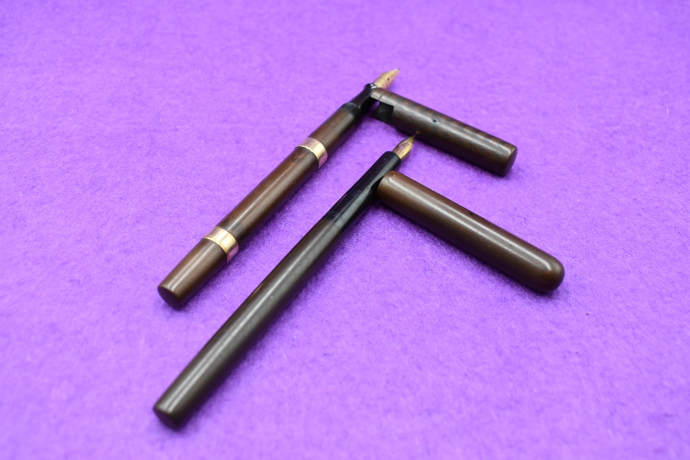 Two early 20th century fountain pens. A Waterman Ideal lever fill with two 9ct gold bands in hard