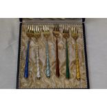 A cased set of six Danish silver gilt and enamel pastry forks of various colours, marked Ela Denmark