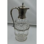 A Victorian cut glass and silver claret jug having domed hinged lid, scroll handle with acanthus