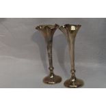A pair of Edwardian silver bud vases having indented frilled rims and weighted bases, London 1909,