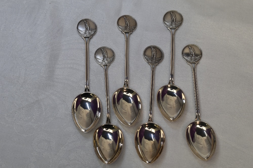 Six 1930's HM silver teaspoons having moulded golf scenes to terminals