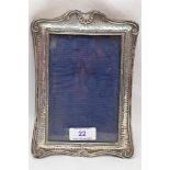 An Edwardian silver photograph frame having plannished decoration and moulded scallop and scroll