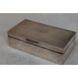 A silver cigarette box having engine turned decoration to lid with inscription to cartouche,
