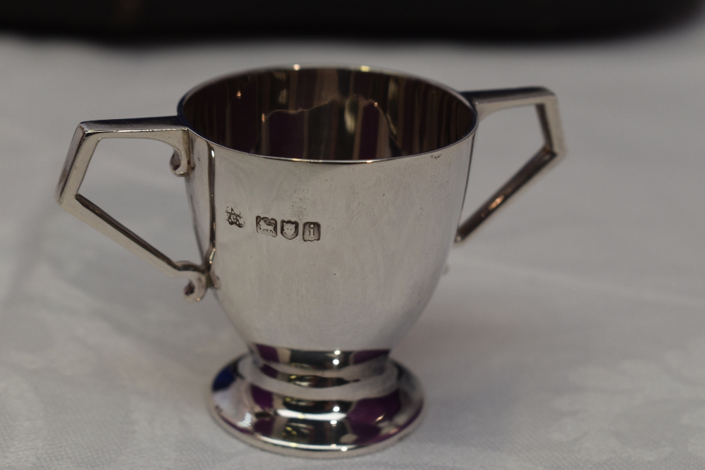 A cased set of six Edwardian silver tot glasses of two handled trophy form, London 1904, Wakeley & - Image 2 of 3