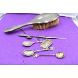 A small selection of HM silver including souvenir spoons, dressing table hair brush, letter opener