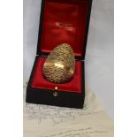 A cased Stuart Devlin 1971 silver gilt surprise Easter egg having a textured exterior opening to