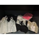 A collection of vintage lingerie including a set of nylon pyjamas, three bras, and five slips, all