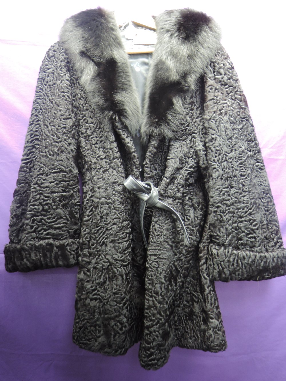 A vintage Astrakhan coat having large fur collar, pockets to sides and belted waist. David Jackson