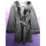 A vintage Astrakhan coat having large fur collar, pockets to sides and belted waist. David Jackson