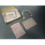 A small lot, around early 20th century, containing a wax flower headdress, two cross stitch samplers