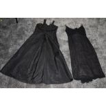 Two 1950s gowns, one in black moiré taffeta having side metal zip, and button decoration to