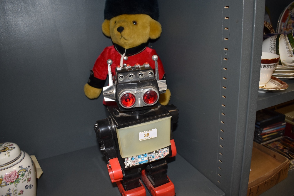 A Merrythought Queens Foot Guard teddy bear along with a modern Chinese battery operated plastic