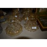 Five small fluted glass lamp shapes having floral pattern.