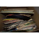 A box of vinyl singles, a variety of genres , including Def Leppard, Iron Maiden and more. Also
