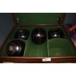 Two pairs of treen Bowling Bowls bearing initials AMC in a traditional leather carry case with the