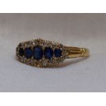 A lady's dress ring having five graduated sapphires within a diamond chip border to moulded