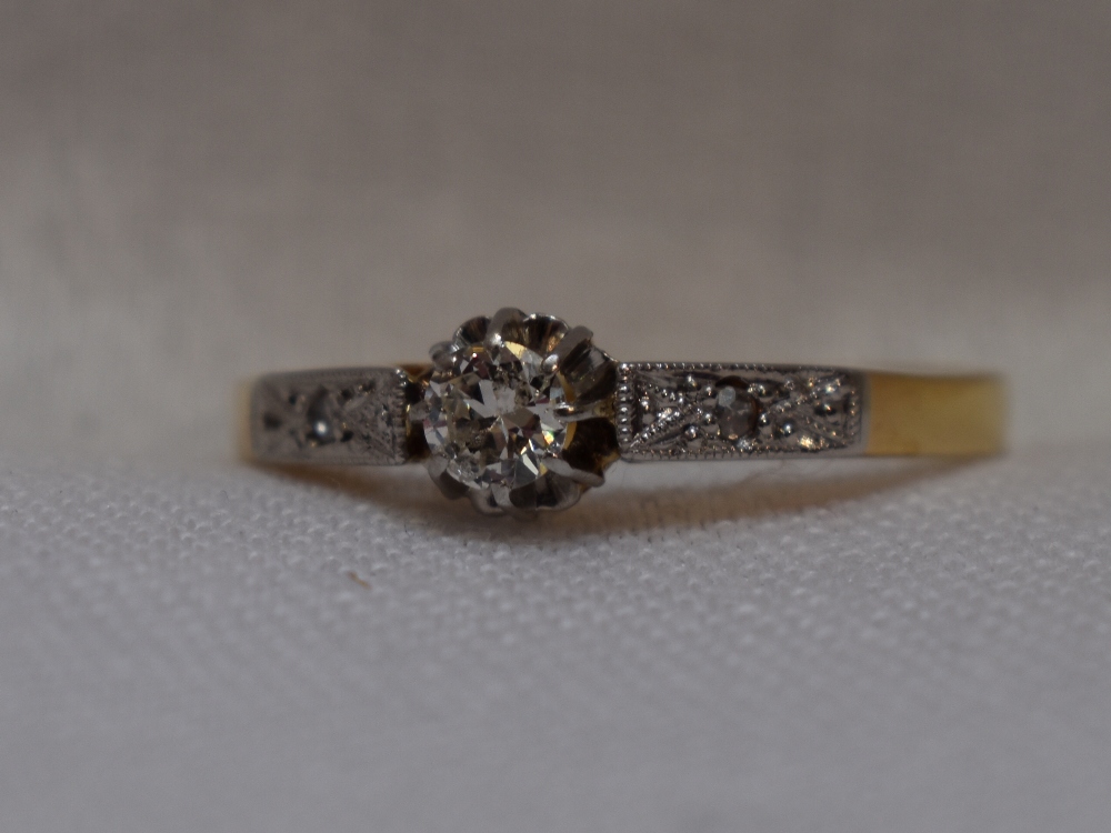 A lady's diamond solitaire dress ring, approx 0.25ct in a decorative claw set mount to diamond set