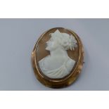 A conche shell cameo brooch depicting a maiden in profile in a plain 9ct rose gold mount