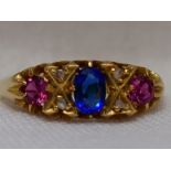 A lady's dress ring having a sapphire style stone flanked by two rubies interspersed by diamond