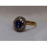 A lady's dress ring having a sapphire and diamond cluster in a claw and pave set mount on a yellow