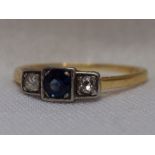 A lady's dress ring having a central sapphire flanked by two diamonds each approx 0.064ct in an