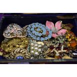 A small jewellery box containing a selection of costume jewellery including brooches