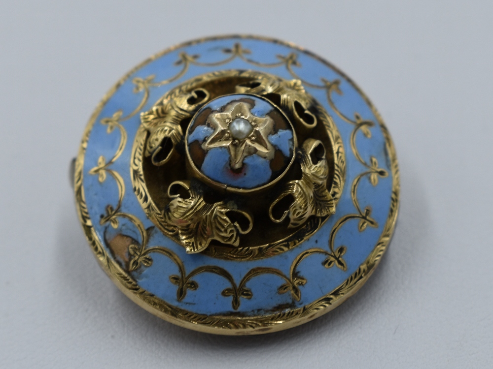 A yellow metal brooch having pale blue enamelled decoration and locket to reverse, no marks tested