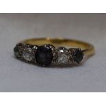 A lady's dress ring having a central alexandrite style stone flanked by graduated diamonds and