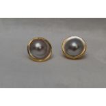 A pair of Australian Broome blister pearl stud earrings in collared yellow metal mounts, no marks,