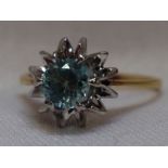 A lady's dress ring having a blue topaz style solitaire in a stylised star burst style raised