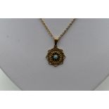 A 9ct gold pendant having turquoise and red paste decoration in a pierced mount on a 9ct gold chain