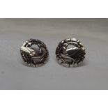 A pair of Georg Jensen Danish silver stud earrings of circular form bearing central doves within a