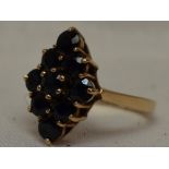 A lady's dress ring having a sapphire lozenge shaped cluster in a claw set basket mount on a 9ct