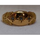 A lady's 18ct gold band ring having three inset diamond chips with moulded shoulders, size N