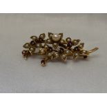 A 9ct gold brooch modelled as a bunch of flowers having cultured and seed pearl and ruby decoration