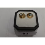 A pair of aqua marine stud earrings in 9ct gold open triple swirl mounts