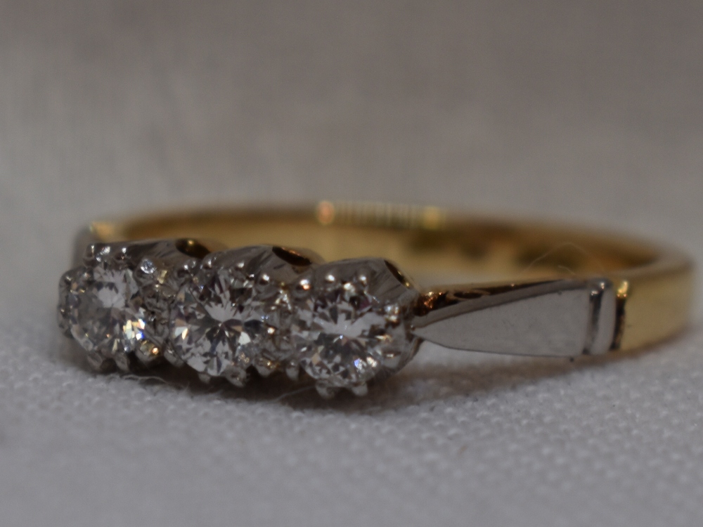 A lady's dress ring having a trilogy of diamonds, total approx 0.15ct in claw set mount to