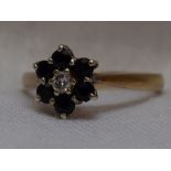 A lady's dress ring having a diamond and sapphire cluster in claw set basket mount on a 9ct gold
