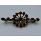 A garnet and seed pearl bar brooch in yellow metal mount stamped 9ct