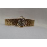 A lady's Uno 9ct gold wrist watch having a baton numeral dial to circularl face on a fixed woven