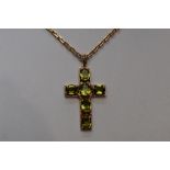 A 9ct gold cross having peridot stones in an open mount on a 9ct gold chain, approx 15' & piece of