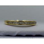 A lady's half eternity ring having fourteen channel set diamond chips, total approx 0.2ct, on an