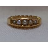A lady's dress ring having five graduated seed pearls in a gallery mount on a 15ct gold loop, size