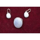 A lady's oversized dress ring having an oval white striped quartz cabouchon in a collared mount to