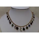 A multi coloured gem stone fringe necklace of graduated oval and round facetted form in claw set