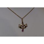 A yellow metal Edwardian style pendant and chain stamped 9K having ruby decoration, chain approx