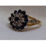 A lady's dress ring having a sapphire and diamond triple cluster to open raised shoulders on an 18ct