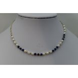 A baroque pearl and lapis lazuli necklace having yellow metal bead spacers and a 9ct gold figaro